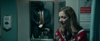 Movie still from “Halloween Kills” (2021), directed by David Gordon Green – A woman standing in front of a mirror in a bathroom; Medium shot, Over the shoulder angle