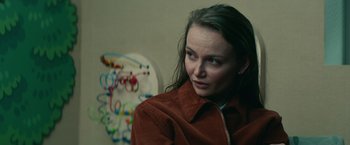 Movie still from “Halloween Kills” (2021), directed by David Gordon Green – A woman in a brown jacket sitting in front of a wall; Close Up shot, Over the shoulder angle