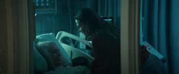 Movie still from “Halloween Kills” (2021), directed by David Gordon Green – A woman sitting in a hospital bed next to a patient; Medium shot, Over the shoulder angle