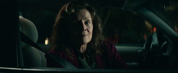 Movie still from “Halloween Kills” (2021), directed by David Gordon Green – An older woman sitting in the back seat of a car; Close Up shot, Over the shoulder angle