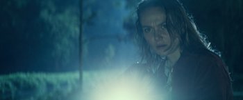 Movie still from “Halloween Kills” (2021), directed by David Gordon Green – A young woman standing in the dark looking at the camera; Close Up shot, Low angle