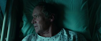 Movie still from “Halloween Kills” (2021), directed by David Gordon Green – An older man laying in a hospital bed; Close Up shot, Overhead angle