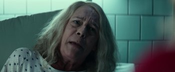 Movie still from “Halloween Kills” (2021), directed by David Gordon Green – An older woman with long hair is looking at the camera; Close Up shot, High angle