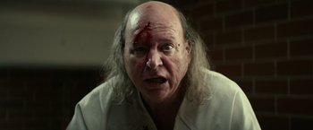 Movie still from “Halloween Kills” (2021), directed by David Gordon Green – An old man with a shaved head and a red forehead; Close Up shot, Low angle