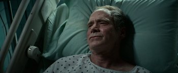 Movie still from “Halloween Kills” (2021), directed by David Gordon Green – An older man laying in a hospital bed with his eyes closed; Close Up shot, Overhead angle