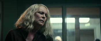 Movie still from “Halloween Kills” (2021), directed by David Gordon Green – An older woman with long blonde hair looking to her left; Close Up shot, Over the shoulder angle