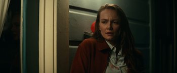 Movie still from “Halloween Kills” (2021), directed by David Gordon Green – A woman in a brown jacket standing next to a door; Close Up shot, Over the shoulder angle
