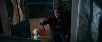 Movie still from “Halloween Kills” (2021), directed by David Gordon Green – A woman holding a knife in a room; Medium shot, High angle