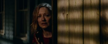 Movie still from “Halloween Kills” (2021), directed by David Gordon Green – A woman standing next to a wooden wall; Close Up shot, Over the shoulder angle