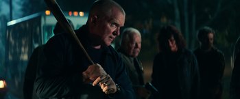 Movie still from “Halloween Kills” (2021), directed by David Gordon Green – A man holding a baseball bat while standing next to another man; Medium shot, Over the shoulder angle