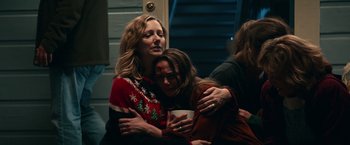 Movie still from “Halloween Kills” (2021), directed by David Gordon Green – Two women hugging each other in front of a staircase; Medium shot, Over the shoulder angle
