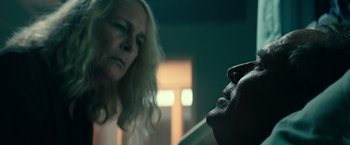 Movie still from “Halloween Kills” (2021), directed by David Gordon Green – A woman looking at a man's face in a dark room; Close Up shot, Over the shoulder angle