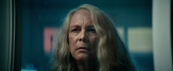 Movie still from “Halloween Kills” (2021), directed by David Gordon Green – An older woman with long blonde hair stares at the camera; Close Up shot, Low angle