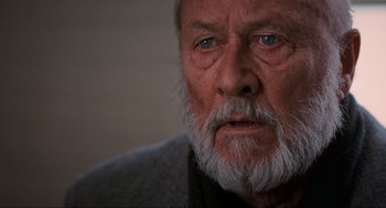 Movie still from “Halloween: The Curse of Michael Myers” (1995), directed by Joe Chappelle – An old man with a beard and blue eyes; Close Up shot, Over the shoulder angle