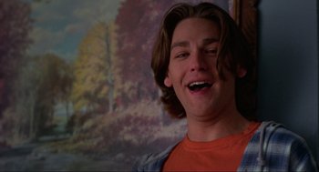 Movie still from “Halloween: The Curse of Michael Myers” (1995), directed by Joe Chappelle – A young man with long brown hair is smiling for the camera; Close Up shot, Low angle