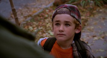 Movie still from “Halloween: The Curse of Michael Myers” (1995), directed by Joe Chappelle – A young boy wearing a plaid hat and a backpack; Close Up shot, High angle