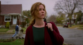 Movie still from “Halloween: The Curse of Michael Myers” (1995), directed by Joe Chappelle – A woman holding a cell phone in her hand while standing on the side of the road; Medium shot, Low angle