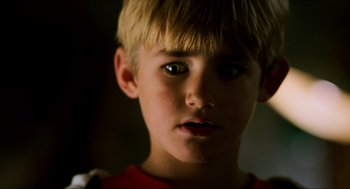 Movie still from “Halloween: The Curse of Michael Myers” (1995), directed by Joe Chappelle – A young boy's face in a dark room; Close Up shot, Low angle