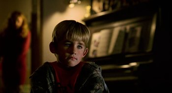 Movie still from “Halloween: The Curse of Michael Myers” (1995), directed by Joe Chappelle – A young boy sitting in front of a bookshelf; Close Up shot, Low angle