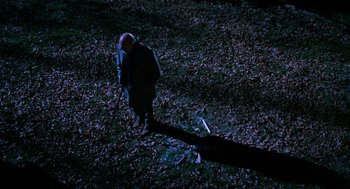 Movie still from “Halloween: The Curse of Michael Myers” (1995), directed by Joe Chappelle – A man walking in the woods at night; Wide shot, High angle