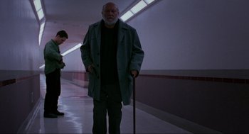 Movie still from “Halloween: The Curse of Michael Myers” (1995), directed by Joe Chappelle – An older man with a walking stick in a hallway; Wide shot, Low angle