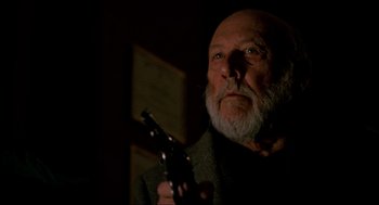 Movie still from “Halloween: The Curse of Michael Myers” (1995), directed by Joe Chappelle – An older man holding a gun in a dark room; Close Up shot, Low angle