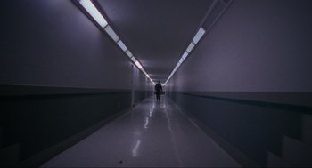 Movie still from “Halloween: The Curse of Michael Myers” (1995), directed by Joe Chappelle – A person is walking down a hallway in a building; Extreme Wide shot, Low angle