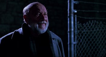 Movie still from “Halloween: The Curse of Michael Myers” (1995), directed by Joe Chappelle – An old man with a beard is standing in the dark; Close Up shot, Low angle