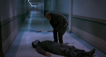 Movie still from “Halloween: The Curse of Michael Myers” (1995), directed by Joe Chappelle – A man standing next to a man laying on the ground; Wide shot, High angle