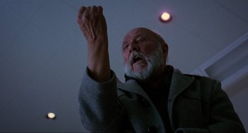 Movie still from “Halloween: The Curse of Michael Myers” (1995), directed by Joe Chappelle – An old man with a beard is holding his arm up; Close Up shot, Low angle