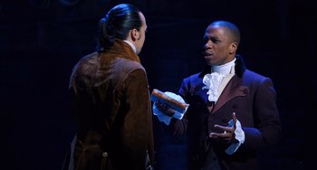 Movie still from “Hamilton” (2020), directed by Thomas Kail – Two men are standing in a room talking; Medium shot, Over the shoulder angle