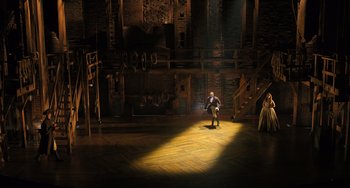 Movie still from “Hamilton” (2020), directed by Thomas Kail – A man sitting on the floor of a theater; Extreme Wide shot, High angle