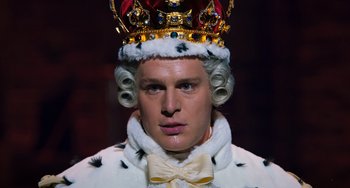 Movie still from “Hamilton” (2020), directed by Thomas Kail – A man in a crown and a fur coat; Close Up shot, High angle