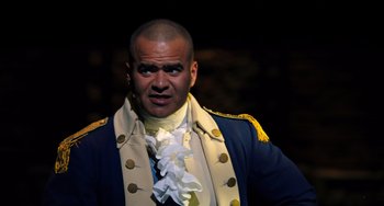 Movie still from “Hamilton” (2020), directed by Thomas Kail – A man in a blue and white jacket and a white and gold jacket; Close Up shot, Low angle
