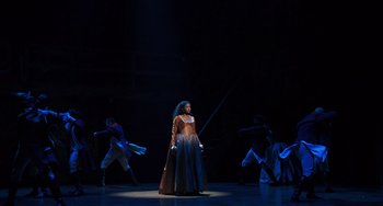 Movie still from “Hamilton” (2020), directed by Thomas Kail – A woman standing in front of a group of people; Extreme Wide shot, Over the shoulder angle