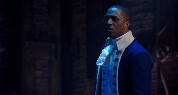 Movie still from “Hamilton” (2020), directed by Thomas Kail – A man wearing a blue jacket and a white tie; Close Up shot, Over the shoulder angle
