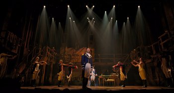 Movie still from “Hamilton” (2020), directed by Thomas Kail – A group of people on a stage with lights in the background; Extreme Wide shot, Low angle