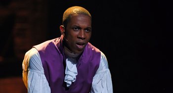 Movie still from “Hamilton” (2020), directed by Thomas Kail – A man wearing a purple vest and a white shirt; Close Up shot, High angle