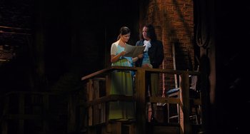 Movie still from “Hamilton” (2020), directed by Thomas Kail – Two people standing on a balcony reading a sheet of paper; Medium shot, Low angle