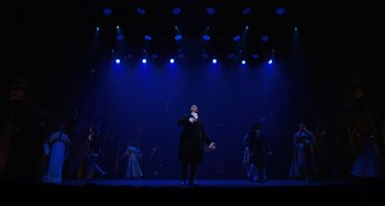 Movie still from “Hamilton” (2020), directed by Thomas Kail – A man standing on a stage in front of a group of people; Extreme Wide shot, Low angle