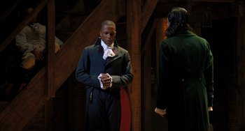 Movie still from “Hamilton” (2020), directed by Thomas Kail – A man and a woman standing next to each other; Medium shot, Over the shoulder angle