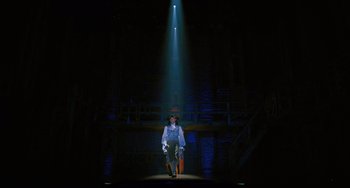 Movie still from “Hamilton” (2020), directed by Thomas Kail – A man standing on a stage under a beam of light; Extreme Wide shot, Low angle