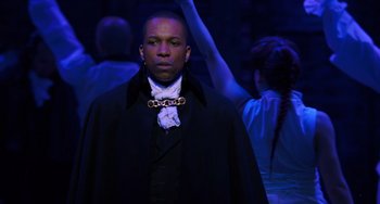 Movie still from “Hamilton” (2020), directed by Thomas Kail – A man in a black jacket and a white shirt; Medium shot, Over the shoulder angle