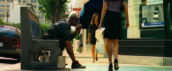 Movie still from “Hancock” (2008), directed by Peter Berg – A man squatting on the ground next to a woman; Wide shot, Low angle