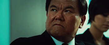 Movie still from “Hancock” (2008), directed by Peter Berg – A person wearing a suit and tie; Close Up shot, Low angle