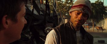 Movie still from “Hancock” (2008), directed by Peter Berg – A person wearing a vest and a hat; Close Up shot, Low angle
