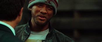 Movie still from “Hancock” (2008), directed by Peter Berg – A person wearing a jacket and a hat; Close Up shot, Over the shoulder angle