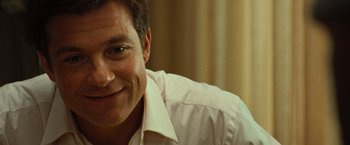 Movie still from “Hancock” (2008), directed by Peter Berg – A person wearing a white shirt smiling; Close Up shot, Over the shoulder angle