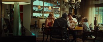 Movie still from “Hancock” (2008), directed by Peter Berg – A group of people sitting at a table in front of a window; Wide shot, Over the shoulder angle