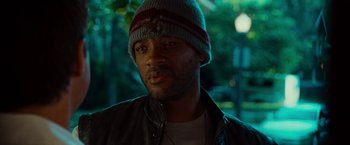 Movie still from “Hancock” (2008), directed by Peter Berg – A person wearing a jacket and a hat; Close Up shot, Low angle